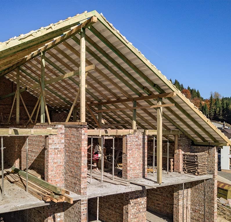 Zimmerer von Blang Holzbau montieren eine vorgefertigte Holzrahmenwand auf einer Baustelle in Luxemburg